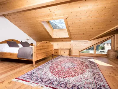 an attic bedroom with a bed and a rug at Apartment Die Sonnailles apartment by Interhome in Chamonix-Mont-Blanc
