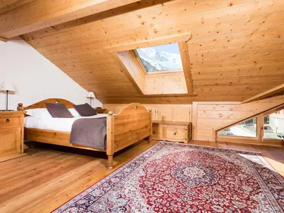 a bedroom with a bed and a large rug at Apartment Die Sonnailles apartment by Interhome in Chamonix-Mont-Blanc