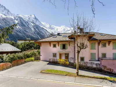 a house on a street with mountains in the background at Apartment Die Sonnailles apartment by Interhome in Chamonix-Mont-Blanc