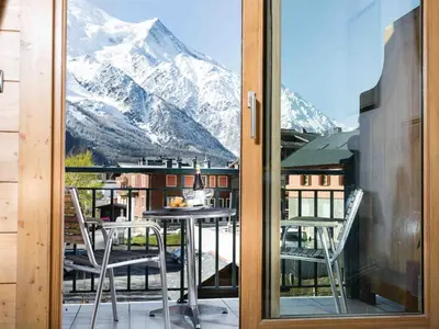a balcony with a table and chairs and a mountain view at Apartment Die Sonnailles apartment by Interhome in Chamonix-Mont-Blanc