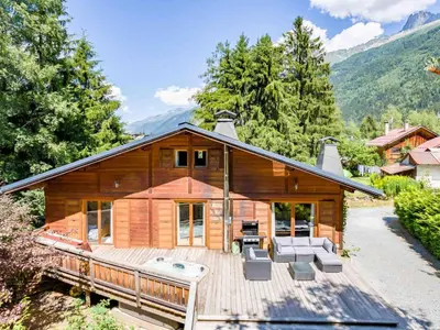 a log home with a large deck with a grill at Holiday Home Chalet des Souchettes by Interhome in Chamonix-Mont-Blanc