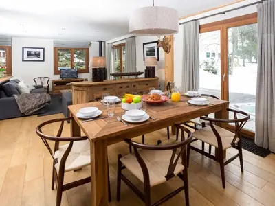 a kitchen and living room with a wooden table and chairs at Holiday Home Chalet des Souchettes by Interhome in Chamonix-Mont-Blanc