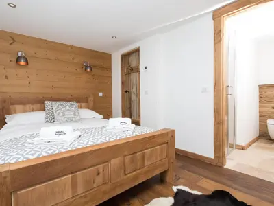 a bedroom with a large bed with wooden walls at Holiday Home Chalet des Souchettes by Interhome in Chamonix-Mont-Blanc