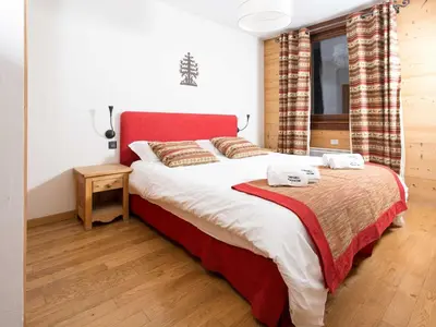 a bedroom with a large bed with a red headboard at Apartment Angenehme Wohnung in Chamonix Centre-Ville by Interhome in Chamonix-Mont-Blanc