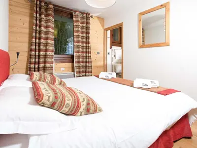 a bedroom with a white bed with two pillows at Apartment Angenehme Wohnung in Chamonix Centre-Ville by Interhome in Chamonix-Mont-Blanc