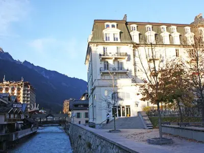 a large white building next to a river at Apartment Wohnung Alpines Museum by Interhome in Chamonix-Mont-Blanc