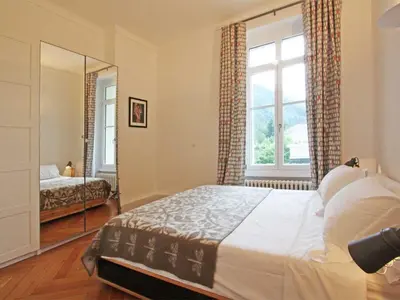 a bedroom with a large bed and a mirror at Apartment Wohnung Alpines Museum by Interhome in Chamonix-Mont-Blanc