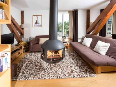 a living room with a fireplace in the middle at Apartment Die Belle Epoque Wohnung by Interhome in Chamonix-Mont-Blanc
