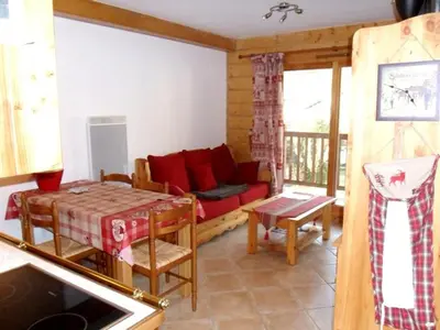 a living room with a red couch and a table at Appartement 6 pers, proche centre Samoëns, parking inclus - FR-1-815-115 in Samoëns