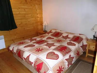 a bedroom with a bed with a blanket on it at Appartement 6 pers, proche centre Samoëns, parking inclus - FR-1-815-115 in Samoëns