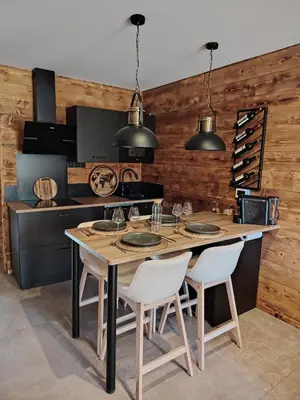 a kitchen with a table with chairs and a counter at La Tanière des Cimes Sauna privé in Passy
