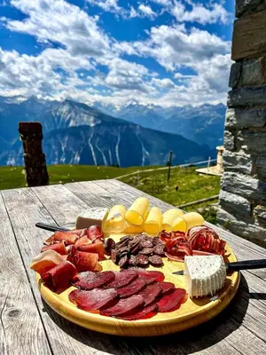 a plate of food on a table with meat and cheese at La Tanière des Cimes Sauna privé in Passy