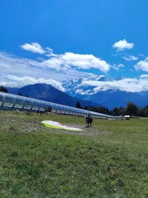 a person standing in a field with a kite at La Tanière des Cimes Sauna privé in Passy