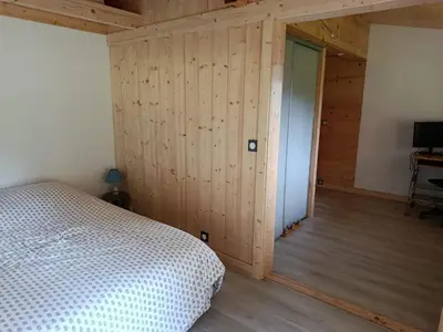 a bedroom with a bed and a door into a room at Chalet vue panoramique in Passy