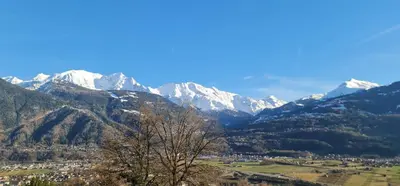 a snow covered mountain range with a town and a tree at Calm & Cozy Apartment with Parking in Sallanches in Sallanches