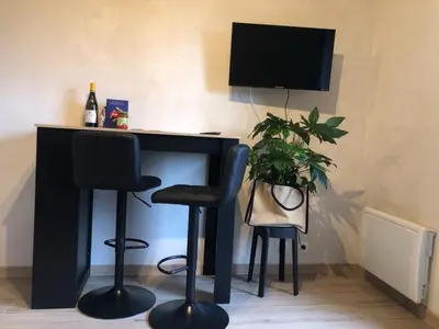 a black desk with two stools and a television at Studio 2 personnes situation idéal a Sallanches 74400 in Sallanches