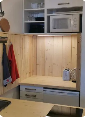 a kitchen with wooden cabinets and a microwave at Jonquille 5 personnes in Chamonix-Mont-Blanc