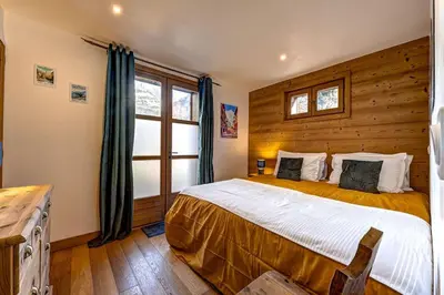 a bedroom with a bed with a wooden wall at Tiny Chalet - near to Servoz train station in Les Houches