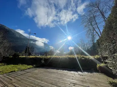 a sun shining in the sky over a wooden boardwalk at Tiny Chalet - near to Servoz train station in Les Houches