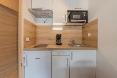 a small kitchen with a sink and a microwave at Chamonix Sud - Grepon 104 - Happy Rentals in Chamonix-Mont-Blanc