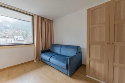 a blue chair in a room with a window at Chamonix Sud - Grepon 104 - Happy Rentals in Chamonix-Mont-Blanc