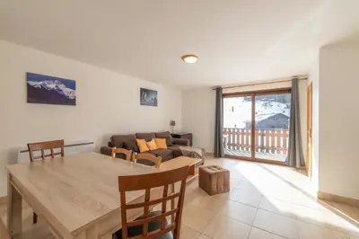 a living room with a table and a couch at Appartement 8 pers –Pied des pistes in Morillon