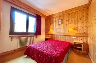 a bedroom with a red bed and a window at Escape Mountain Apartment with Stunning Views in Combloux