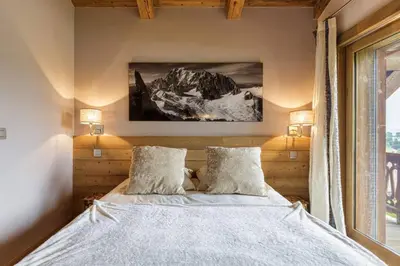a bedroom with a bed with two pillows and a window at Megepi Chalet 5CH Calme Remontee 400m Sauna Fitness in Demi-Quartier
