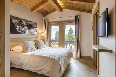 a bedroom with a bed and a large window at Megepi Chalet 5CH Calme Remontee 400m Sauna Fitness in Demi-Quartier