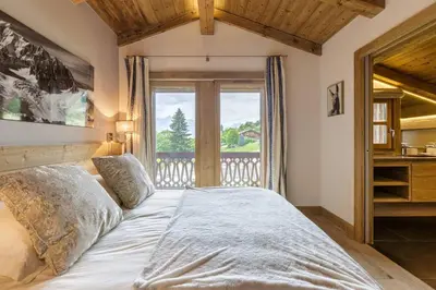 a bedroom with a large bed and a window at Megepi Chalet 5CH Calme Remontee 400m Sauna Fitness in Demi-Quartier