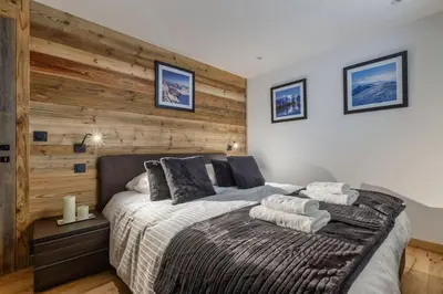 a bedroom with a large bed with a wooden wall at Jacaranda 5 - Sublime 6pax - Central - Confort - Parking in Chamonix-Mont-Blanc