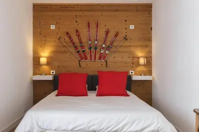 a bedroom with a bed with red pillows at Les Choucas Spacieux 2CH Parking Calme Vues 5mn centre in Chamonix-Mont-Blanc