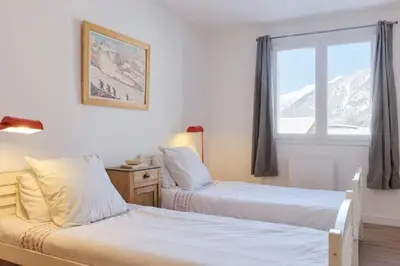 a bedroom with two beds and a window with mountains at Les Choucas Spacieux 2CH Parking Calme Vues 5mn centre in Chamonix-Mont-Blanc