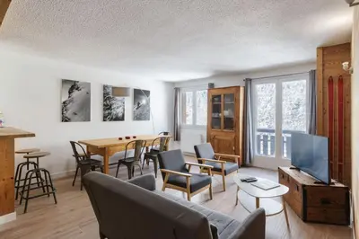 a living room with a couch and a table at Les Choucas Spacieux 2CH Parking Calme Vues 5mn centre in Chamonix-Mont-Blanc