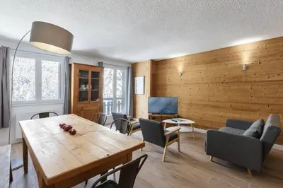 a living room with a table and chairs at Les Choucas Spacieux 2CH Parking Calme Vues 5mn centre in Chamonix-Mont-Blanc