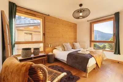 a bedroom with a bed and a chair and a window at Terra Losa AlpinChic 2CH Central Remontee Vue Parking in Les Houches