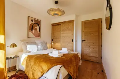 a bedroom with a bed with two towels on it at Terra Losa AlpinChic 2CH Central Remontee Vue Parking in Les Houches