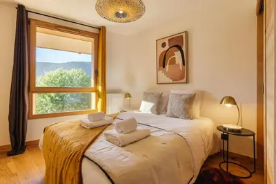 a bedroom with a large bed with two pillows on it at Terra Losa AlpinChic 2CH Central Remontee Vue Parking in Les Houches