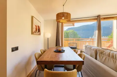 a living room with a table and a couch at Terra Losa AlpinChic 2CH Central Remontee Vue Parking in Les Houches