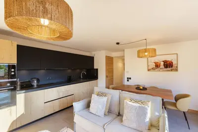 a kitchen and living room with a couch and a table at Terra Losa AlpinChic 2CH Central Remontee Vue Parking in Les Houches