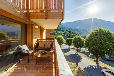 a balcony with a table and a view of a mountain at Terra Losa AlpinChic 2CH Central Remontee Vue Parking in Les Houches