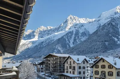 a town with snow covered mountains in the background at La Verte Appart 2CH familial 5mn pistes Vue Parking in Les Houches