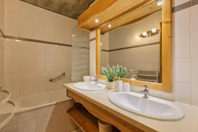 a bathroom with two sinks and a tub and a mirror at La Verte Appart 2CH familial 5mn pistes Vue Parking in Les Houches