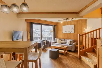 a living room with a table and a couch at La Verte Appart 2CH familial 5mn pistes Vue Parking in Les Houches