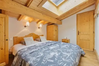 a bedroom with a large bed with a wooden ceiling at La Verte Appart 2CH familial 5mn pistes Vue Parking in Les Houches