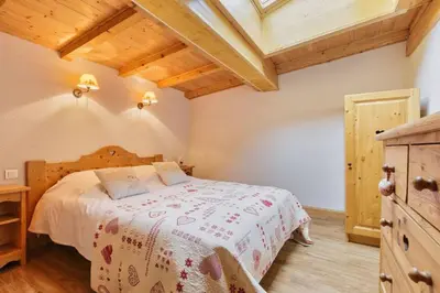 a bedroom with a bed and a wooden ceiling at La Verte Appart 2CH familial 5mn pistes Vue Parking in Les Houches