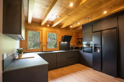 a kitchen with stainless steel appliances and wooden ceilings at Grosse Pierre Chalet 180m2 Cheminee Jacuzzi Vue Taconnaz in Les Houches