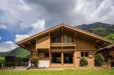 a log house with mountains in the background at Grosse Pierre Chalet 180m2 Cheminee Jacuzzi Vue Taconnaz in Les Houches
