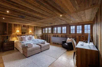 a bedroom with a bed and a desk and a couch at Peter Pan Chalet Luxe Sauna Jacuzzi Cinema Vue 180 in Les Houches