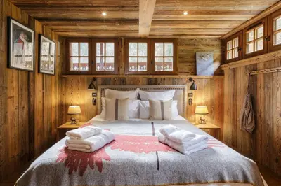a bedroom with a bed with two towels on it at Peter Pan Chalet Luxe Sauna Jacuzzi Cinema Vue 180 in Les Houches